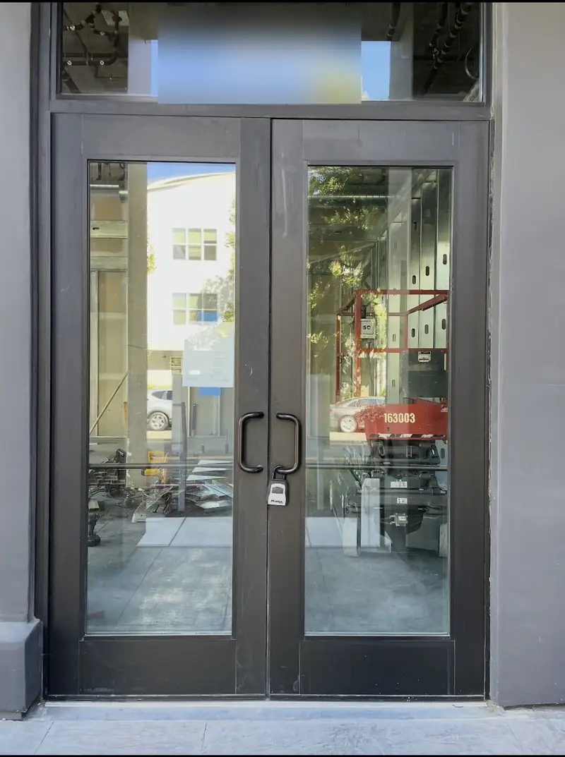 Commercial glass double doors with exit hardware at a building entrance