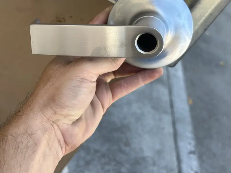 Locksmith holding a new commercial lever lock before installing it